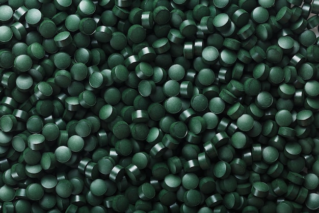 Green tablets from spirulina vegetarian dietary supplement as a fullscreen texture