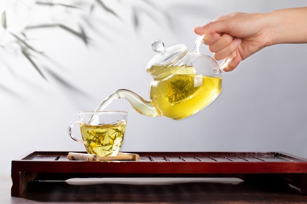 Green tea in glass teapot and cup