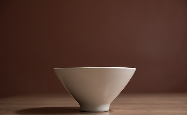 green tea latte in white ceramic cup on wooden table with brown background