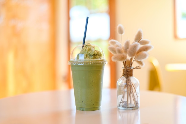 Green tea smoothie plastic cup on wooden table a cup green tea in cafe