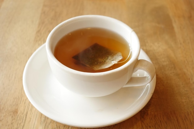 Green tea with tea bag on tiles background