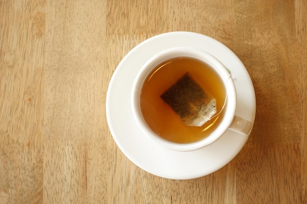 Green tea with tea bag on tiles background