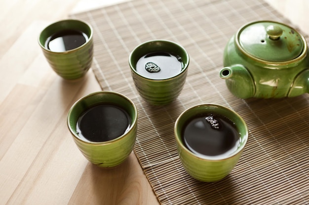 Green teapot and teacups hot drink on wooden table organic product from the nature for healt