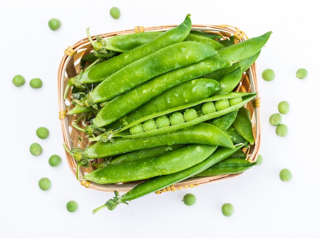 Green, tender, fresh and raw peas. In wicker basket