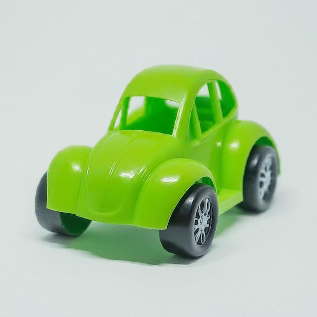 Photo a green toy car with the wheels on the front