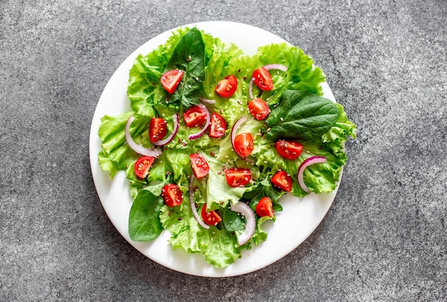 Green vegan salad from vegetables and green leaves mix on stone backgroundHealthy food