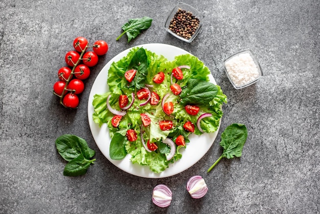 Green vegan salad from vegetables and green leaves mix on stone backgroundHealthy food