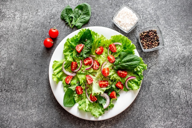 Green vegan salad from vegetables and green leaves mix on stone backgroundHealthy food