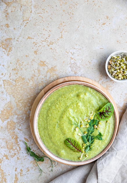 Green vegetable cream soup with micro greens and breadstick Vegan soup puree of green vegetables