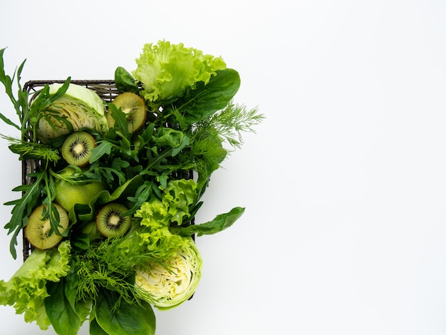 Green vegetables and fruits in basket.