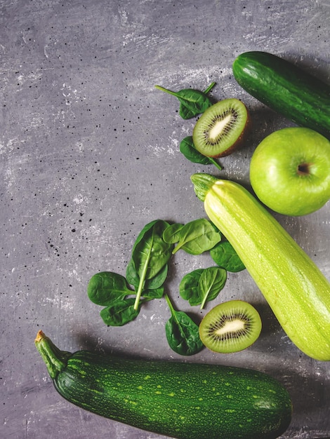 Photo green vegetables and fruits on a gray concrete background