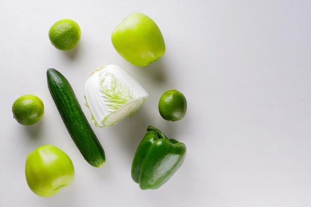 Green vegetables and fruits on white background. Healthy vegetarian food concept. Top view