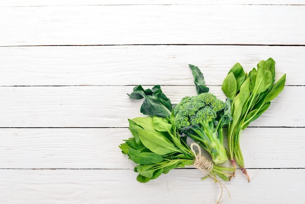 Green vegetables and fruits On a white wooden background Healthy food Top view Copy space