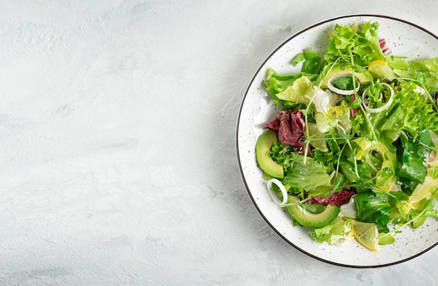 Green vegetables vegan salad Top view on grey stone table