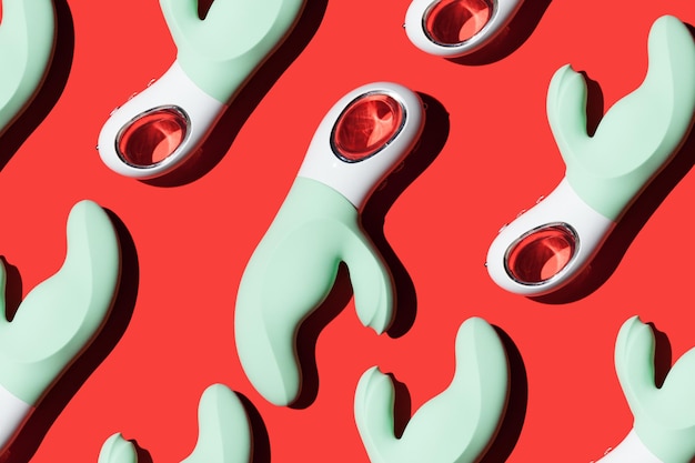 Green vibrators pattern for masturbation on a red background