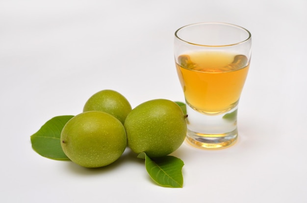 Green walnuts and tincture of them on a white background