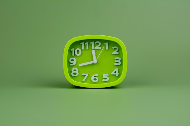 Green watch on a green background concept of time Time planning