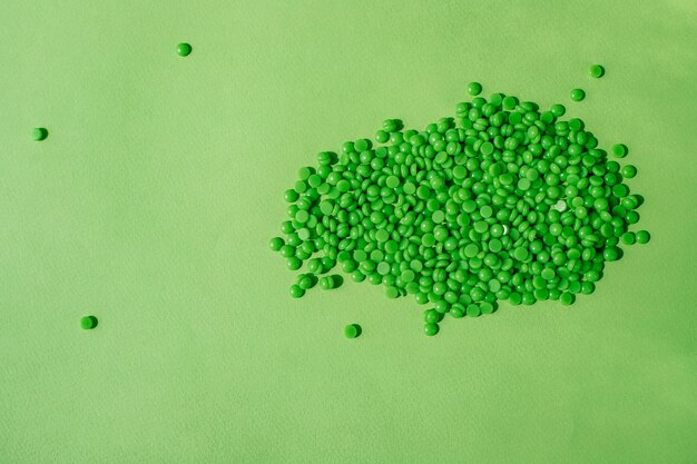 GREEN WAX GRANULES LIE ON A GREEN BACKGROUND