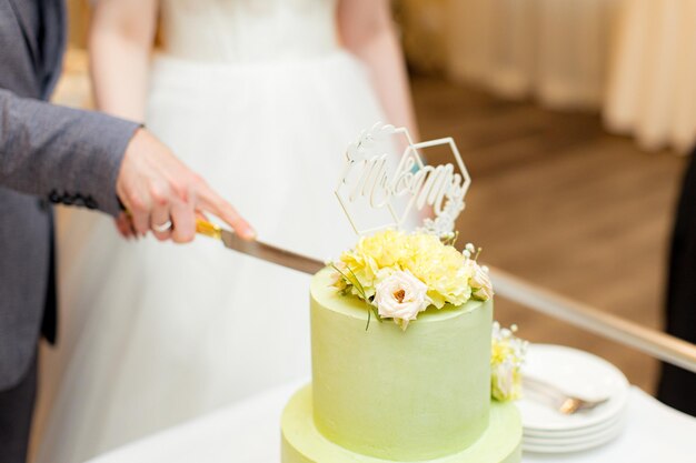 Green wedding cake decorated with flowers