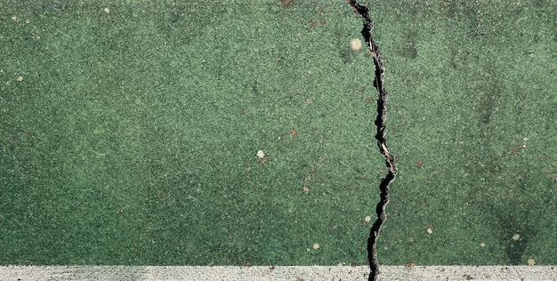 A green and white concrete floor with a crack in the middle.