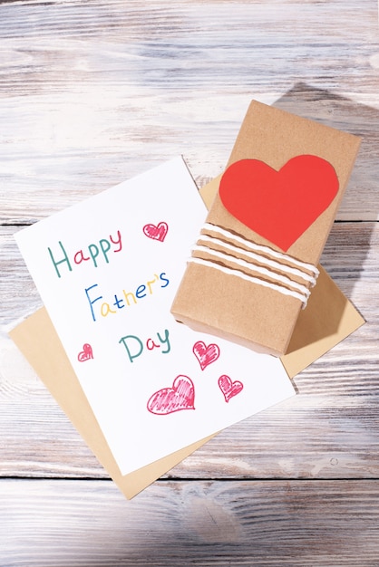 Greeting card made by a child and a gift wrapped in craft paper with a red heart