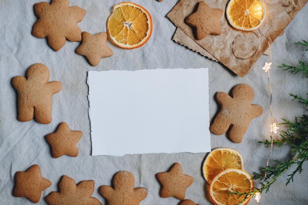 greeting card mockup on the background of gingerbread, holiday sweets, christmas cookies, white shee