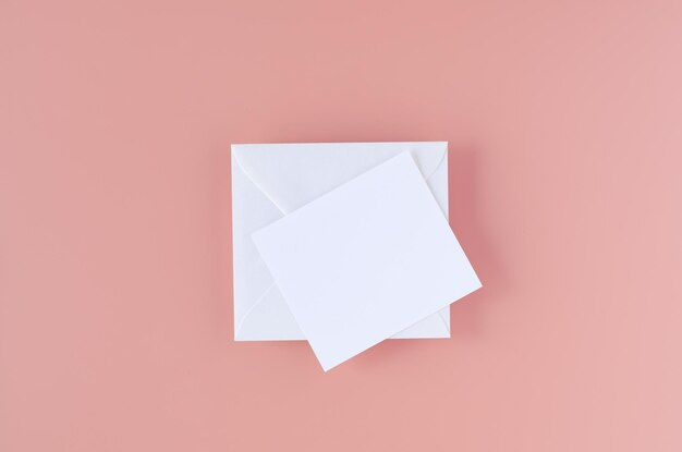 Greeting card with white envelope on pink background