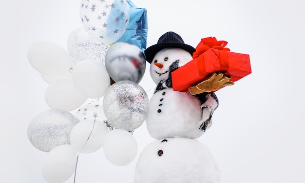 Greeting snowman gentleman with air balloons and gift merry christmas and happy new year