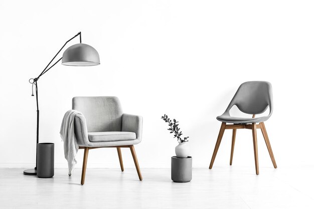 Photo grey armchair with a floor lamp and chair in white room