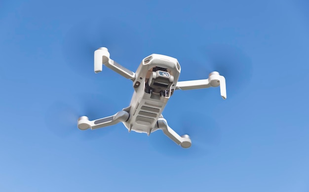 grey drone quadcopter with digital camera and sensors flying in sky