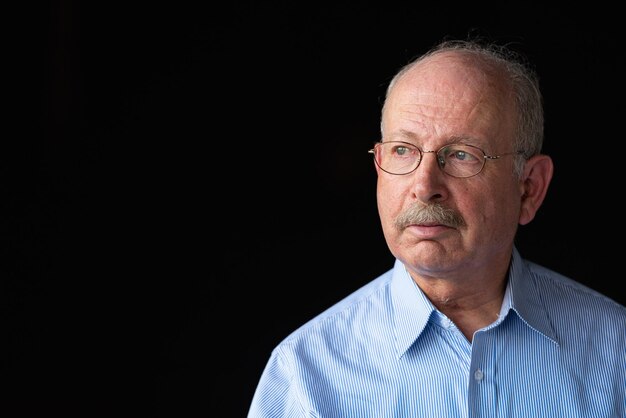 Grey haired senior man with mustache wearing eyeglasses and thinking