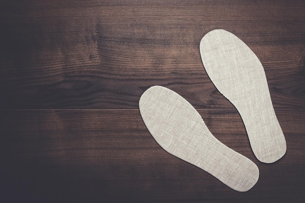 Grey insoles for shoes on wooden background