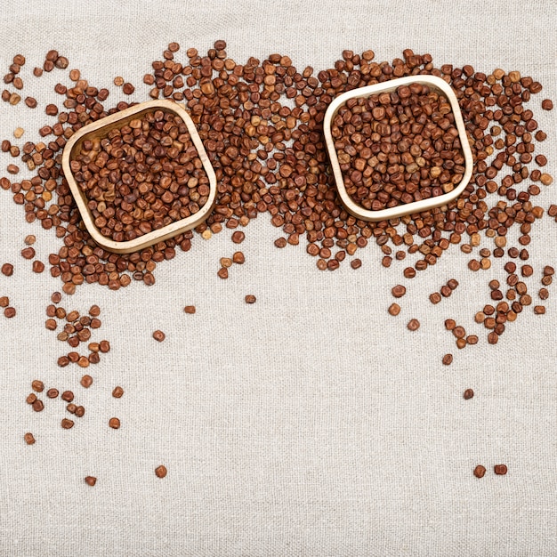 Grey peas in rustic bowls on wooden table.