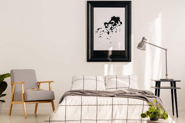 Grey retro armchair in white bedroom interior with wooden accents