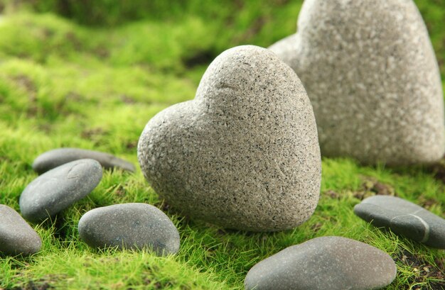 Grey stones in shape of heart on grass background