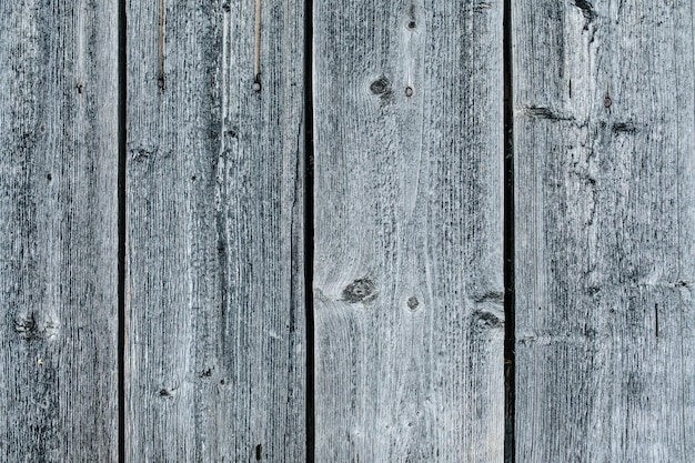 Grey weathered closely packed planks of a wooden fence texture