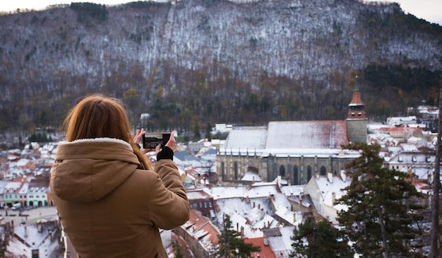 Gril taking a photo of an old city