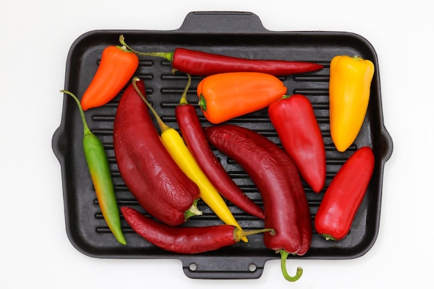 A grill pan with a variety of peppers on it.