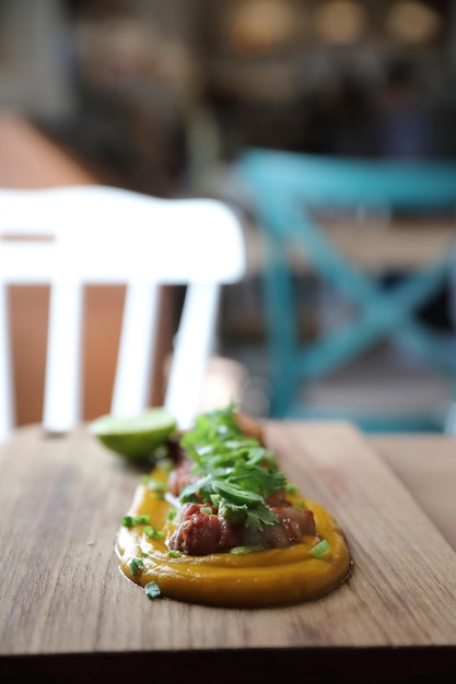 Grilled bacon with pumpkin sauce on wood background