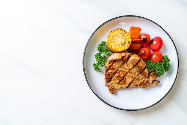 grilled and barbecue fillet pork steak with corn, carrot and tomatoes