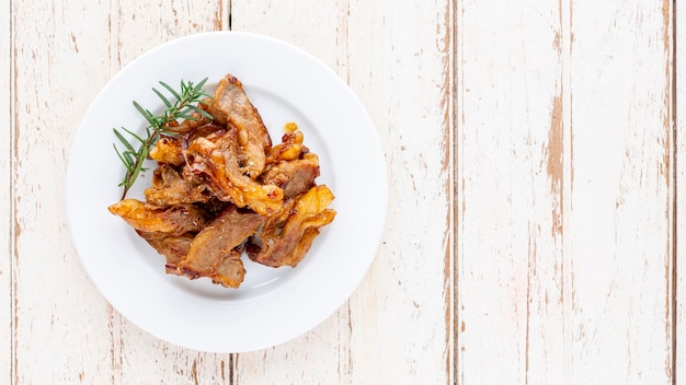 Grilled beef fillet steak meat with oregano and rosemary in white plate on white wood texture background with copy space for text top table view flat lay