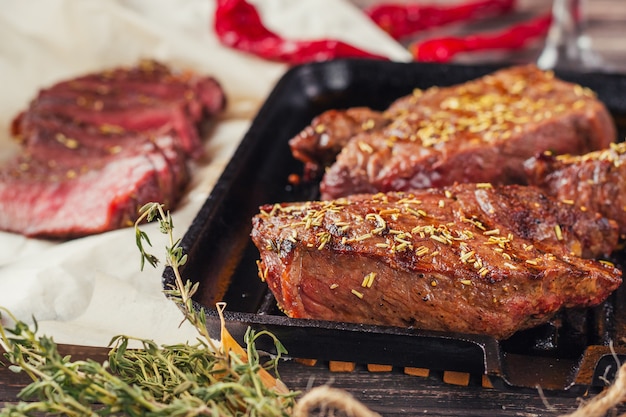 Grilled beef steak on frying pan, top view. Fried chunks of meat close up