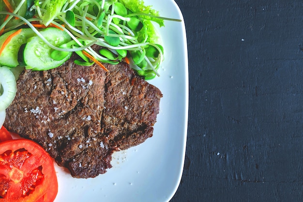 Grilled beef steaks and healthy salads on the table