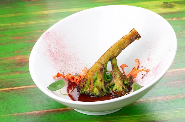 Grilled broccoli with Pad Thai sauce On a colored wooden background Vegetarian dish