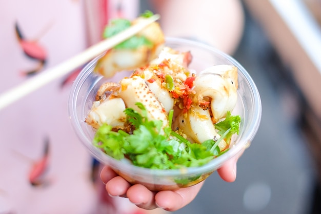 Grilled (Burning) for squid in clear bowl with coriander and seafood sauce.