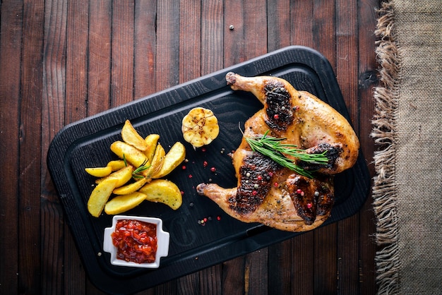 Grilled chicken baked with aromatic herbs and spices Potatoes grill On Wooden background