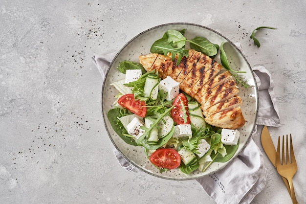 Grilled chicken breast Fried chicken fillet and fresh vegetable salad with tomatoes cucumber and feta cheese Chicken meat with salad Healthy food