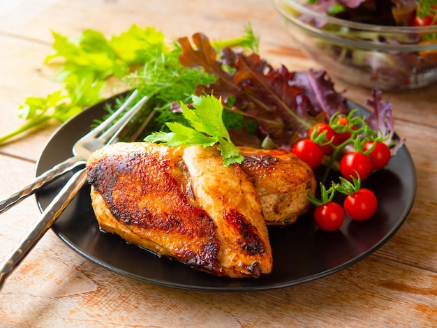 Grilled chicken breast serve with fresh cherry tomato and salad