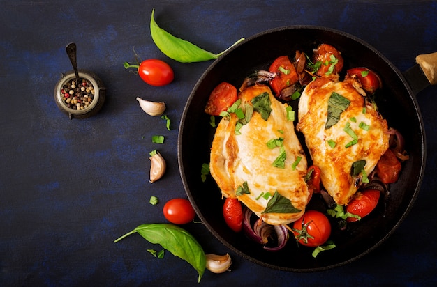 Grilled Chicken breast stuffed with tomatoes, garlic and basil in pan. Top view