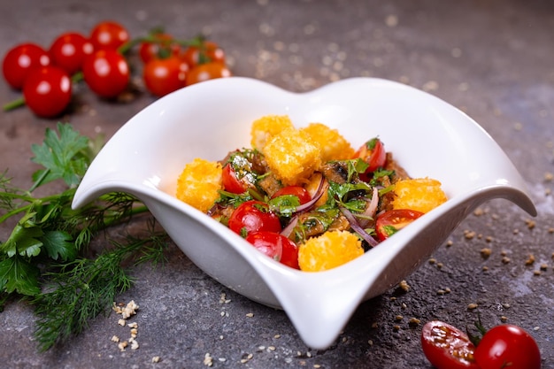 Grilled chicken cheese salad with tomatoes onions and dill in a white bowl